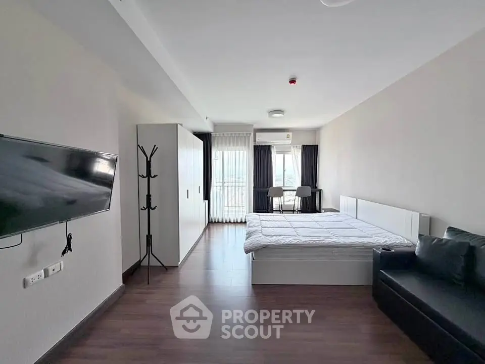 Spacious modern bedroom with large window and sleek furnishings