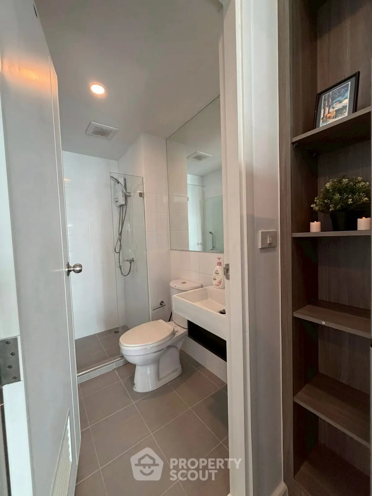 Modern bathroom with glass shower and sleek fixtures in contemporary apartment.