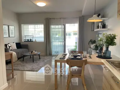 Modern open-plan living room and kitchen with stylish decor and natural light.