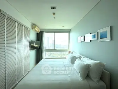 Spacious bedroom with large windows offering stunning city views and modern decor.