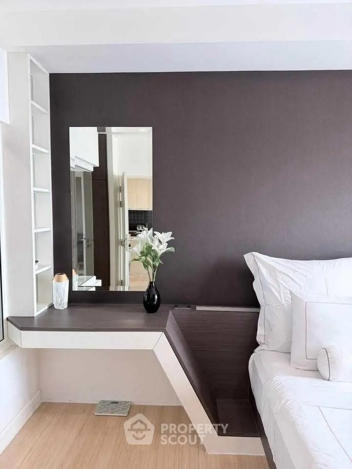 Modern bedroom with sleek design and elegant decor, featuring a stylish mirror and cozy bedding.