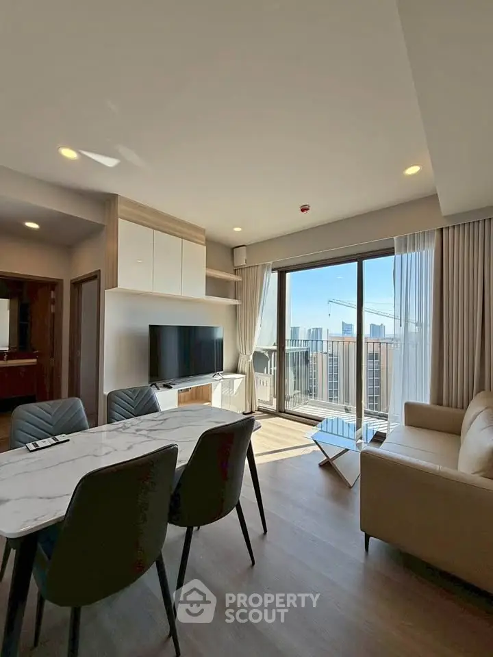 Modern living room with open layout, stylish furniture, and city view balcony in luxury apartment.