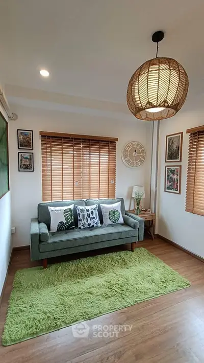 Charming living room with cozy green sofa and stylish decor accents.