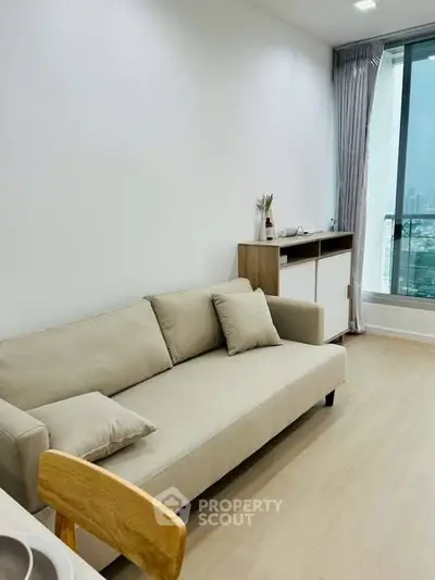 Modern living room with beige sofa and city view window