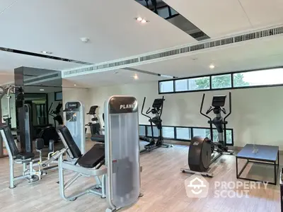 Modern gym with state-of-the-art fitness equipment and large windows for natural light.