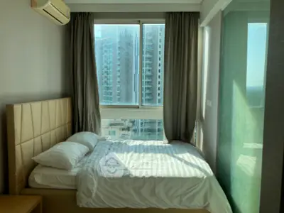 Modern bedroom with large windows and city view, featuring cozy bed and elegant curtains.