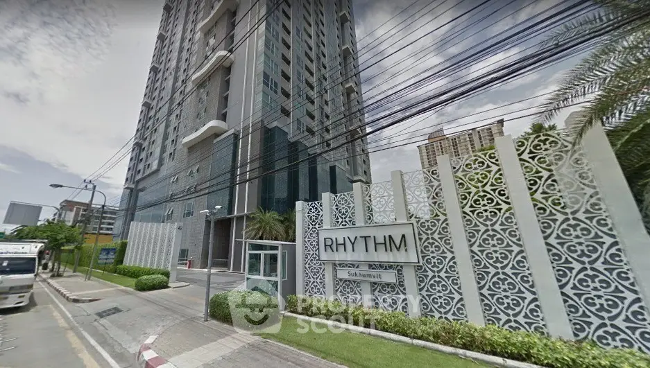 Modern high-rise building with stylish facade and lush landscaping at Rhythm Sukhumvit.