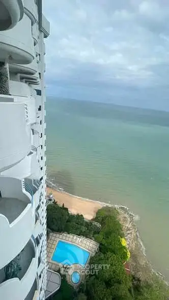 Stunning oceanfront view from high-rise balcony with pool and beach access.