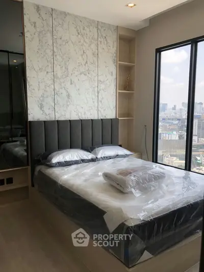 Modern bedroom with city view, featuring stylish headboard and floor-to-ceiling windows.