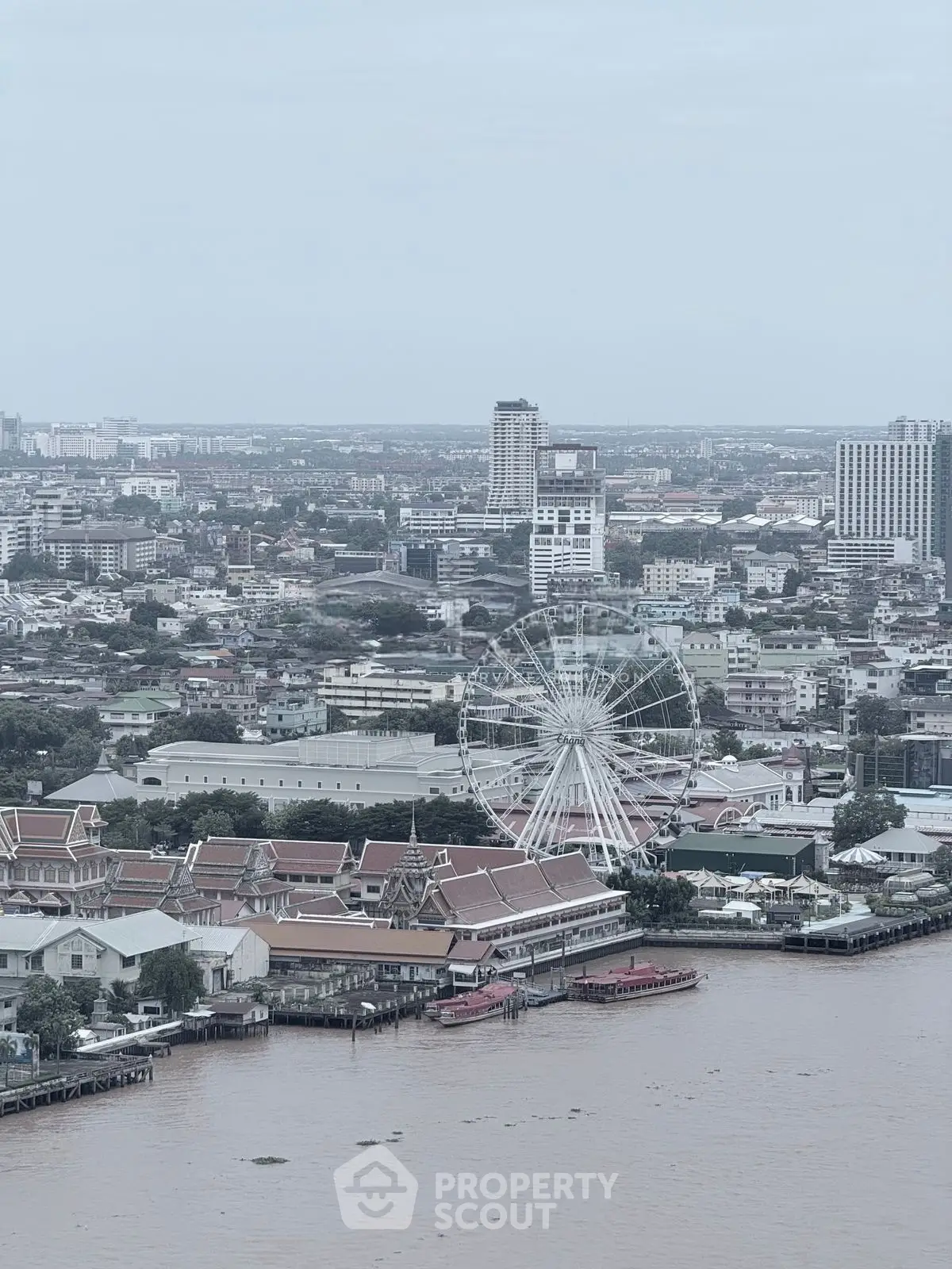 Stunning cityscape view with a Ferris wheel and river, showcasing urban living and entertainment.