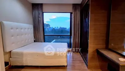 Spacious bedroom with large window offering stunning city view