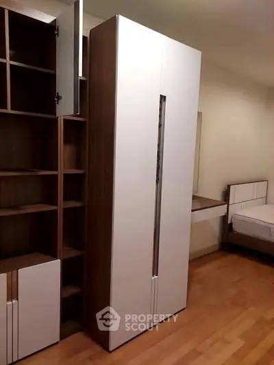 Modern bedroom with sleek wardrobe and wooden flooring