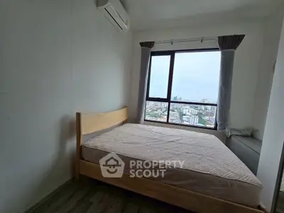 Cozy bedroom with city view, featuring a wooden bed and air conditioning, perfect for urban living.