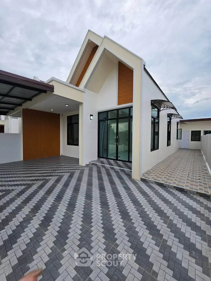 Modern single-story house with unique roof design and spacious driveway