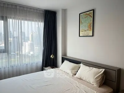 Modern bedroom with city view, featuring a cozy bed and stylish decor.
