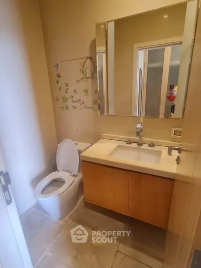 Modern bathroom with sleek vanity and wall art, perfect for a cozy home.