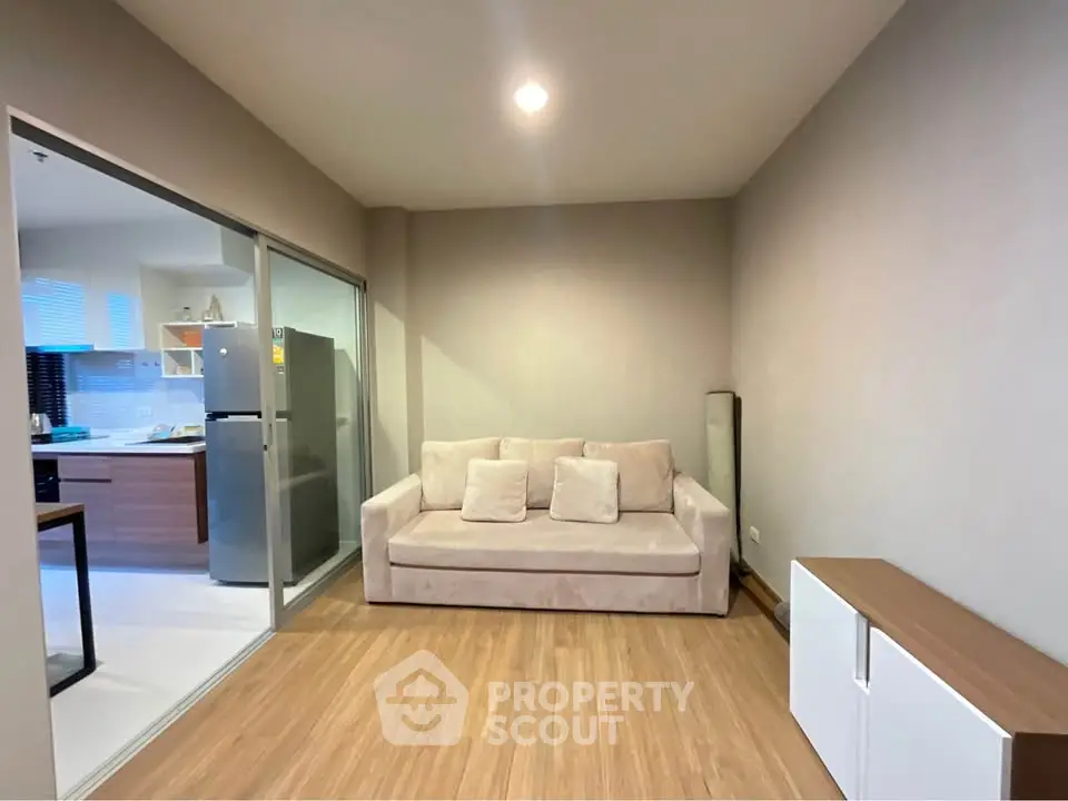 Modern living room with cozy sofa and open kitchen layout in stylish apartment.