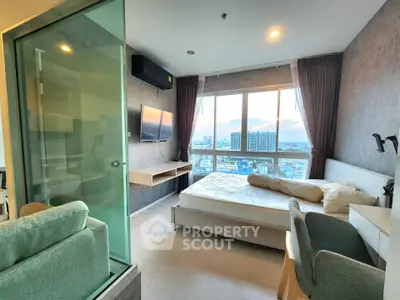 Modern bedroom with city view, featuring a cozy bed, wall-mounted TV, and large window for natural light.