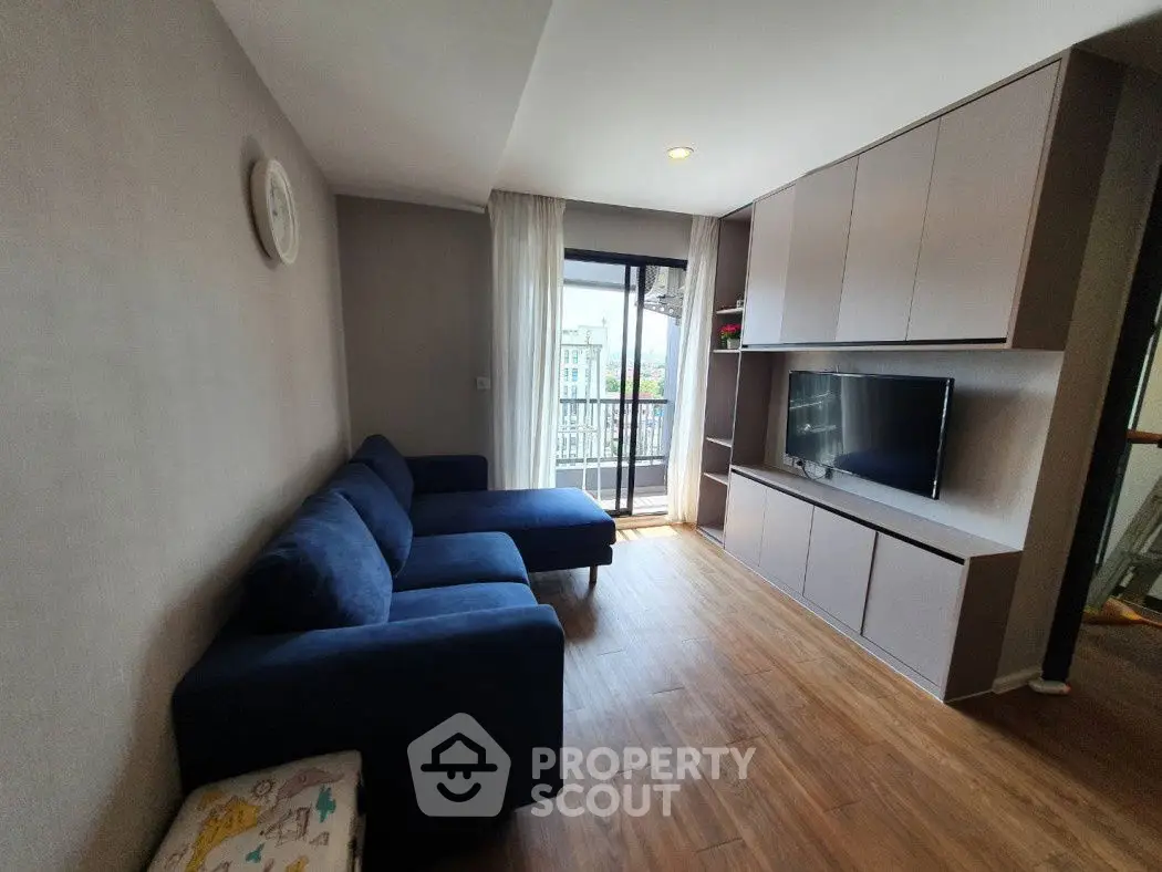 Modern living room with blue sectional sofa and balcony view