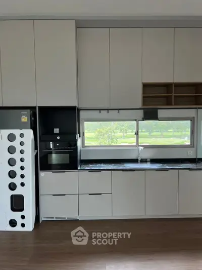 Modern kitchen with sleek cabinetry and large window view