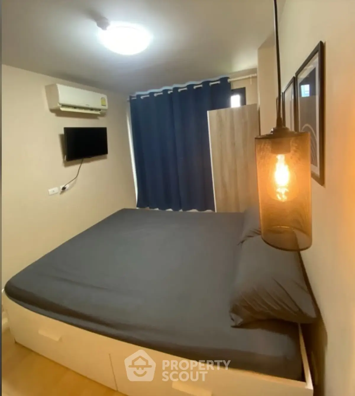 Cozy bedroom with modern lighting and wall-mounted TV, ideal for urban living.