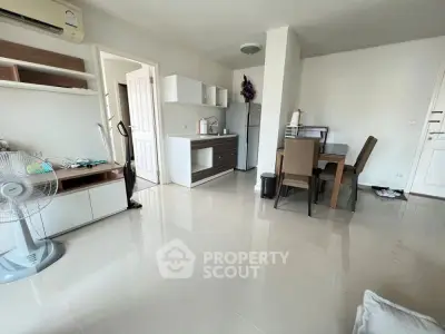 Modern open-plan living and dining area with sleek furniture and bright flooring.