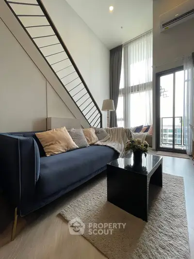 Modern living room with high ceiling and stylish decor in a loft apartment
