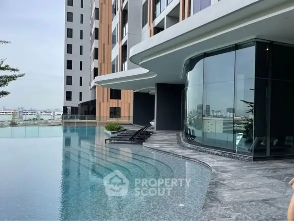 Luxurious modern apartment building with stunning infinity pool and city views.