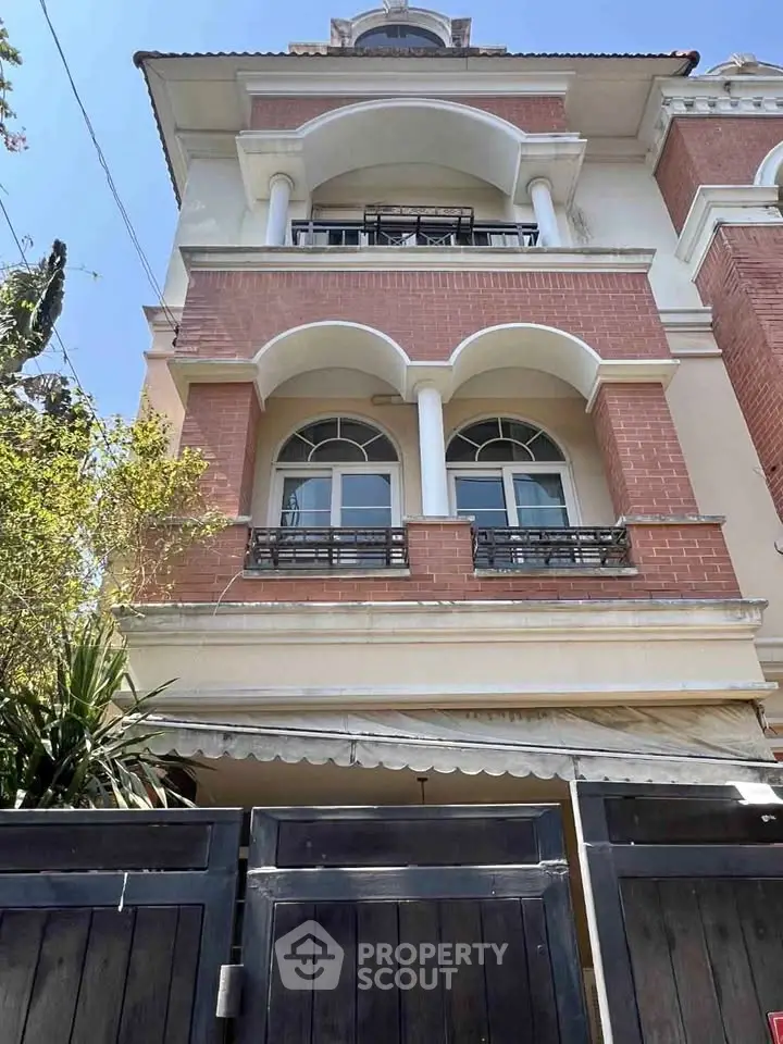 Elegant multi-story brick building with arched windows and balconies, perfect for urban living.