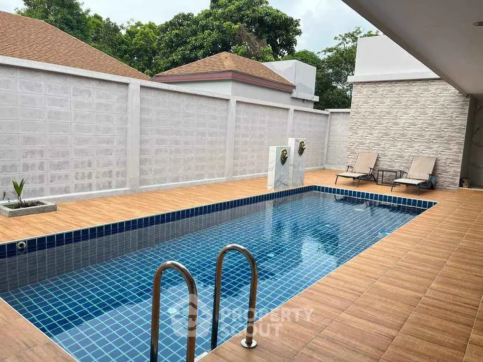 Luxurious private pool area with elegant tile design and comfortable lounge chairs.