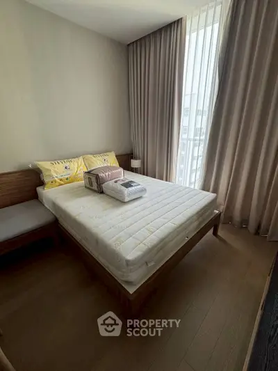 Cozy bedroom with natural light and modern furnishings in a stylish apartment.