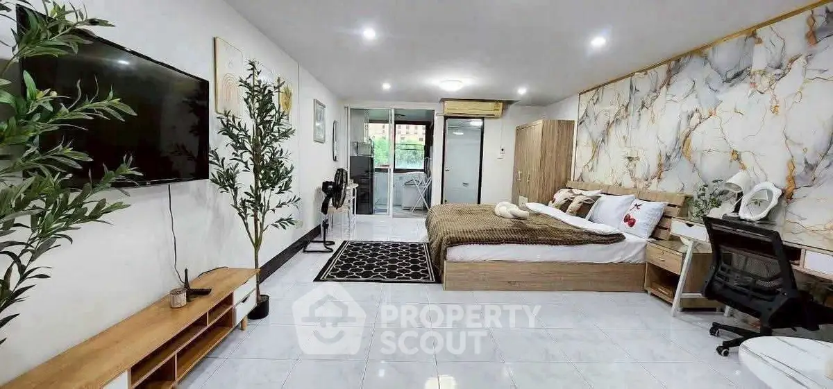 Spacious modern bedroom with elegant decor and large windows for natural light.
