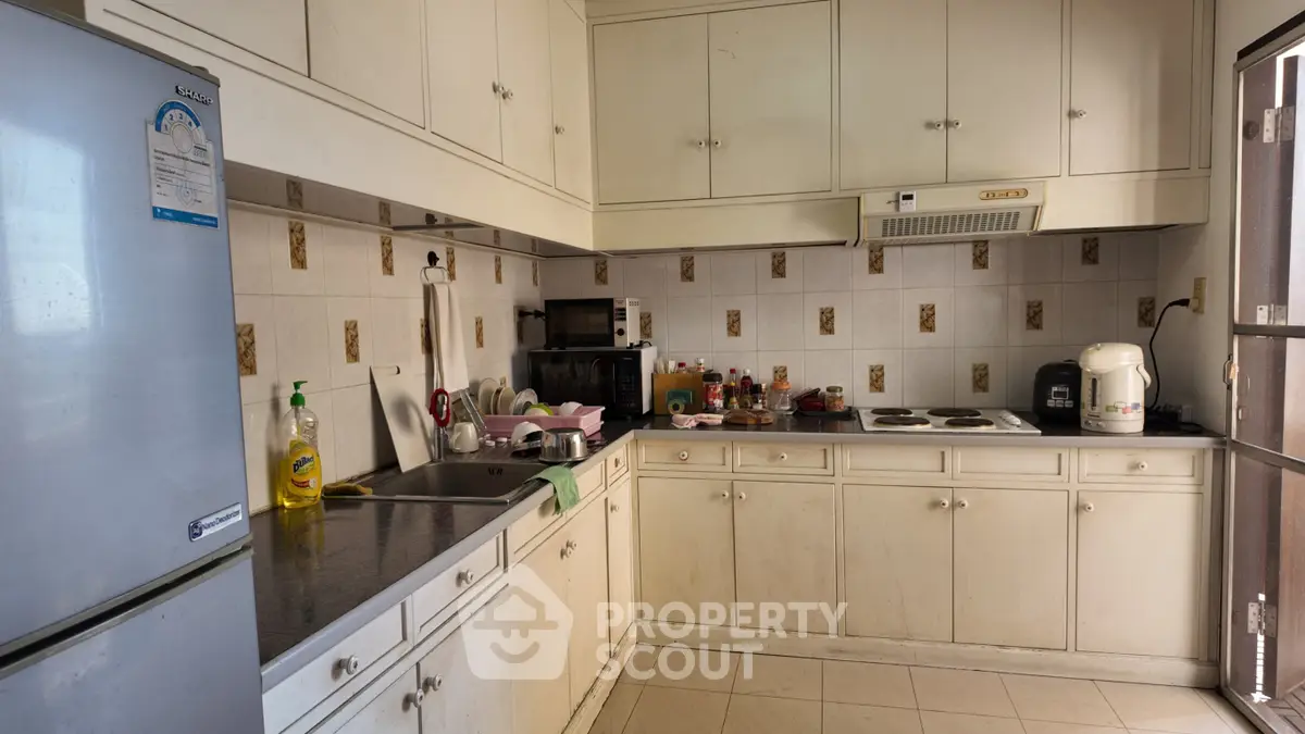 Charming kitchen with closed layout and ample storage, featuring modern appliances and a cozy atmosphere.