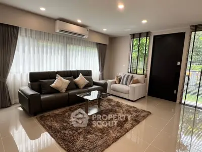 Modern living room with sleek furniture and large windows for natural light.