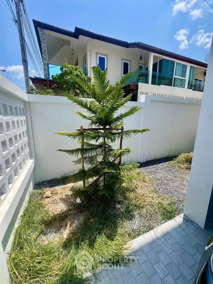Charming modern house with lush garden and balcony, perfect for serene living.