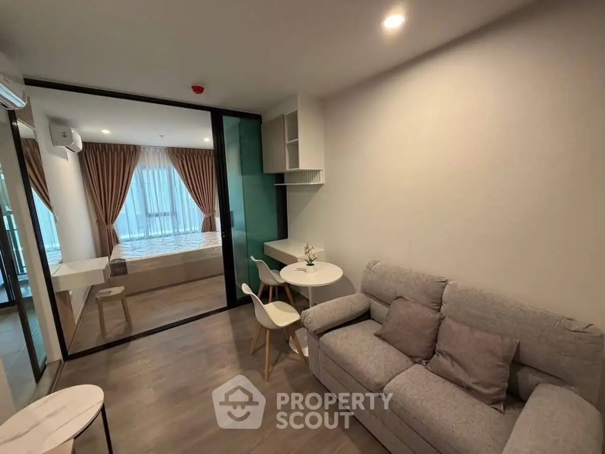 Modern living room with cozy sofa and dining area in open layout apartment.