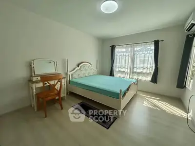 Spacious bedroom with natural light and elegant furnishings