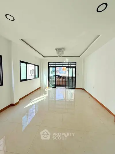 Spacious and bright living room with large windows and modern lighting, perfect for family gatherings.