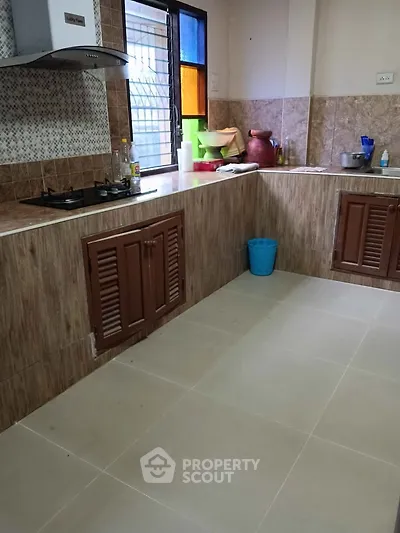 Spacious kitchen with modern gas stove and ample storage space