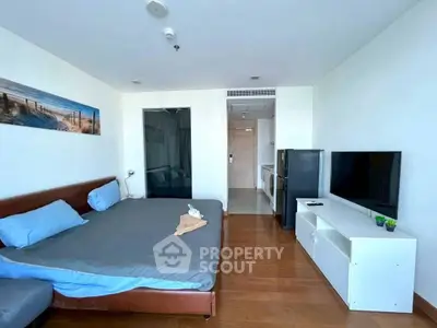 Modern studio apartment with cozy bedroom and sleek kitchen area, perfect for urban living.
