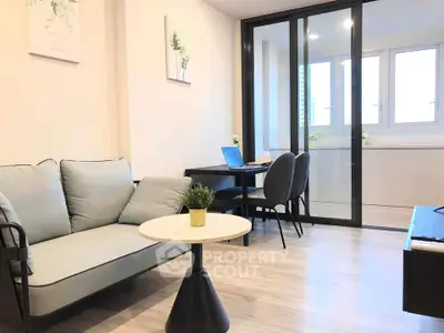 Modern living room with cozy seating and study area, featuring sleek sliding glass doors.