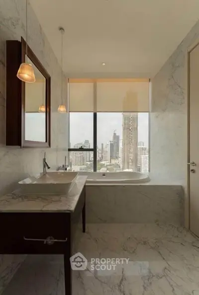 Luxurious bathroom with marble finishes and city view, featuring a modern bathtub and elegant lighting.