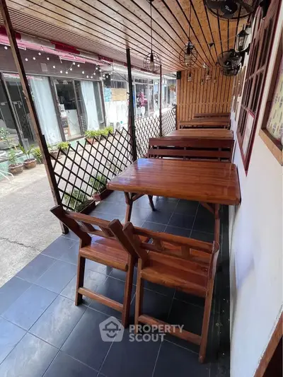 Charming outdoor seating area with wooden furniture and lattice decor, perfect for relaxation.