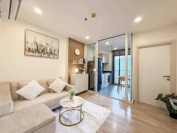 Modern living room with open kitchen, stylish decor, and cozy seating area.