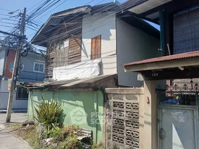 Charming rustic house with unique architectural features and lush greenery in a serene neighborhood.