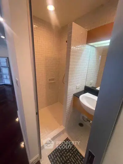 Modern bathroom with sleek shower and stylish vanity in contemporary apartment.