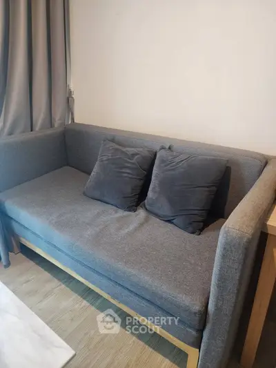 Modern living room with stylish gray sofa and cozy cushions, perfect for relaxation and comfort.