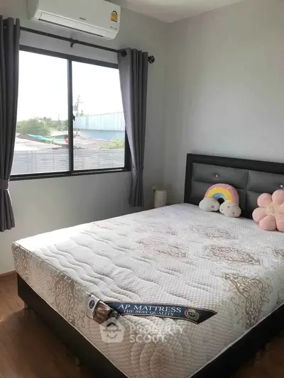 Cozy bedroom with large window and comfortable bed, perfect for relaxation.