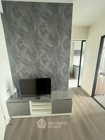 Modern living room with stylish geometric accent wall and sleek TV stand.