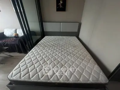 Spacious bedroom with large bed and mirrored wardrobe in modern apartment.